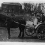 Black and white photo of a man and boy with a milk churn in a cart being pulled by a pony. The cart is marked 'Pan Manor Dairy' over the wheel and Morris, Pan Manor Farm at the front