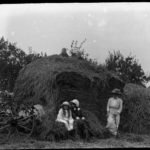 Glass negative of family and haystack