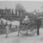 George Guy (aged 16) standing beside Mr Morris's milk float, Newport