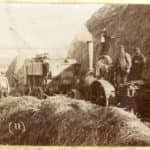 A sepia photograph showing good detail of a threshing machine, crew and steam engine