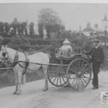 Sepia photograph showing George Guy (aged 16) standing beside Mr Morris's milk float, Newport